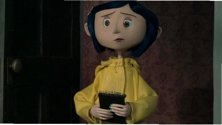 Coraline cầm một chiếc bảng với áo khoác màu vàng
