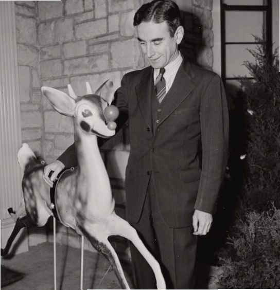 Robert May bên cạnh hình vẽ minh họa chú tuần lộc Rudolph